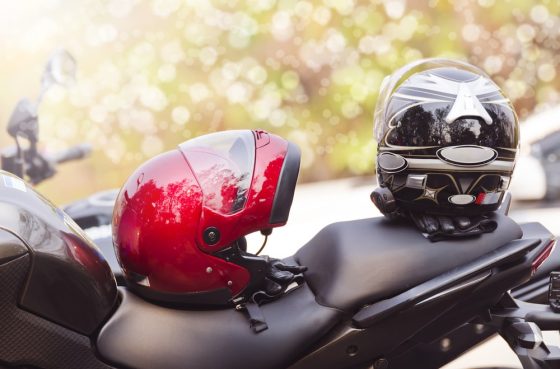two helmets on top of a motorcycle seat