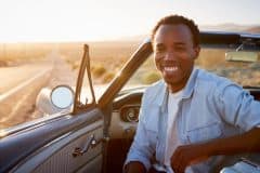 Portrait Of Man Enjoying Road Trip In Open Top Classic Car