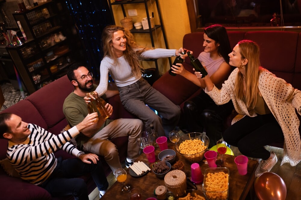 Friends gathering in a living room with snacks and drinks, representing how renters insurance can cover personal property and liability in shared spaces.