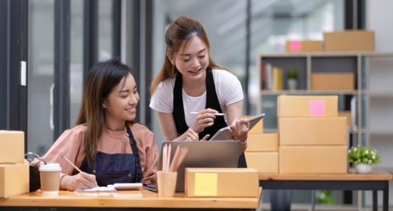 Two Asian women check orders in a small business selling products