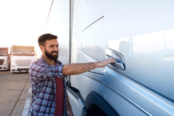 Smiling man standing by his commercial truck