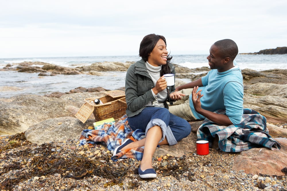 African American couple picniks on the beach