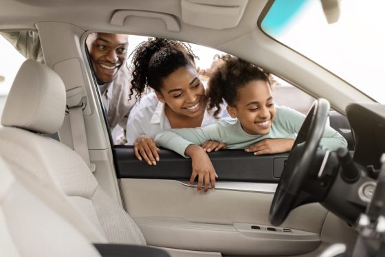 Excited African American family looks at new cars