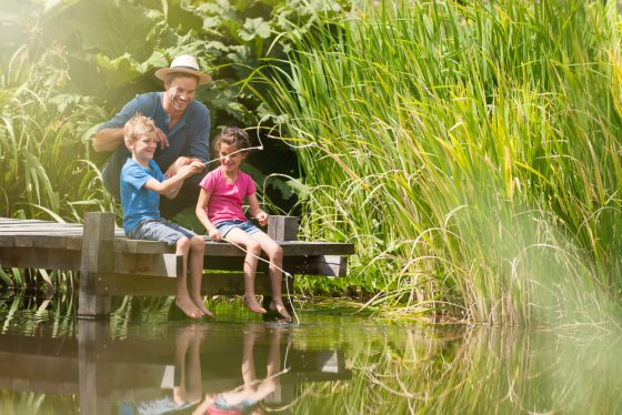 Father and children fish off dock