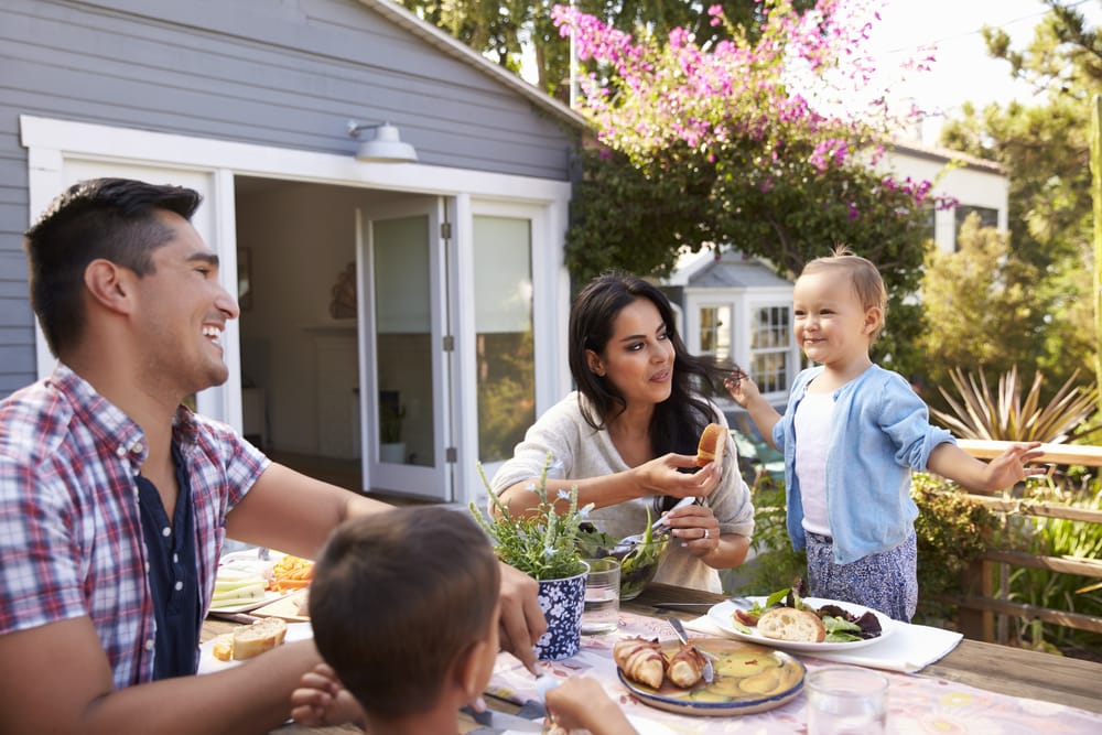 Young happy family enjoying a meal outside on patio