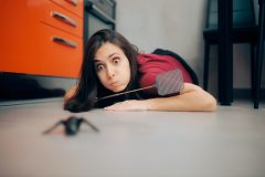 Young woman with a bug swatter faces off with a bug