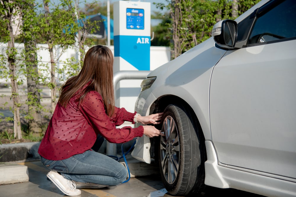 Girl puts air in her tires at service station