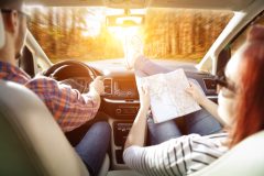 Young couple taking a drive through fall leaves