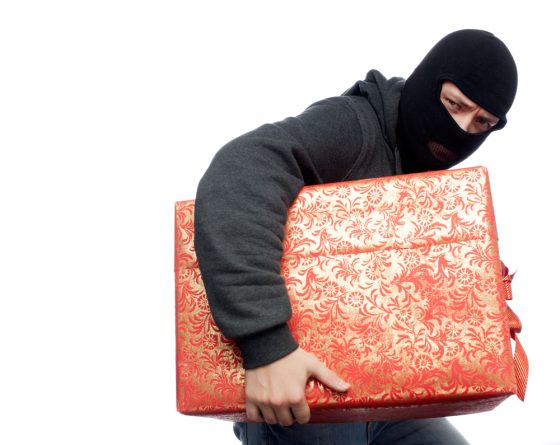 A burglar stealing a wrapped gift - renters insurance in California