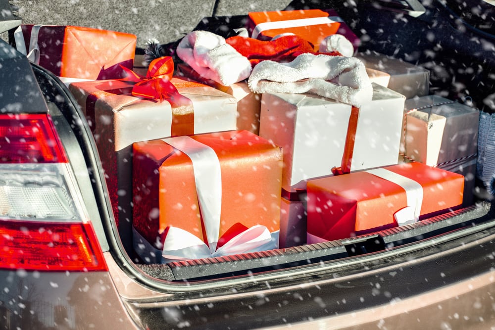 Holiday gifts in the trunk of a car with snow falling - renters insurance in California