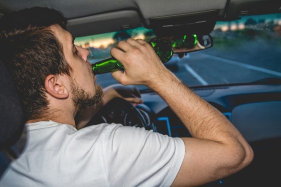 Young man drinking while driving - cheap SR22 insurance in California