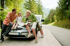 Family stops for a break and to check a map during travels in their RV.