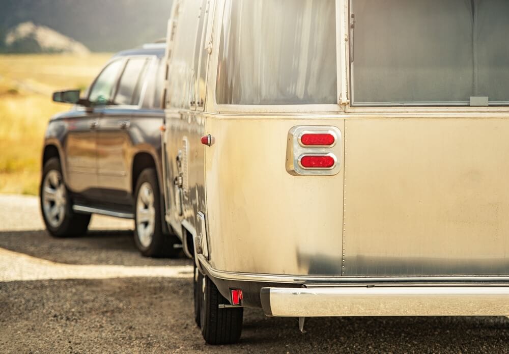 Vehicle pulling a travel trailer during spring RV travels.