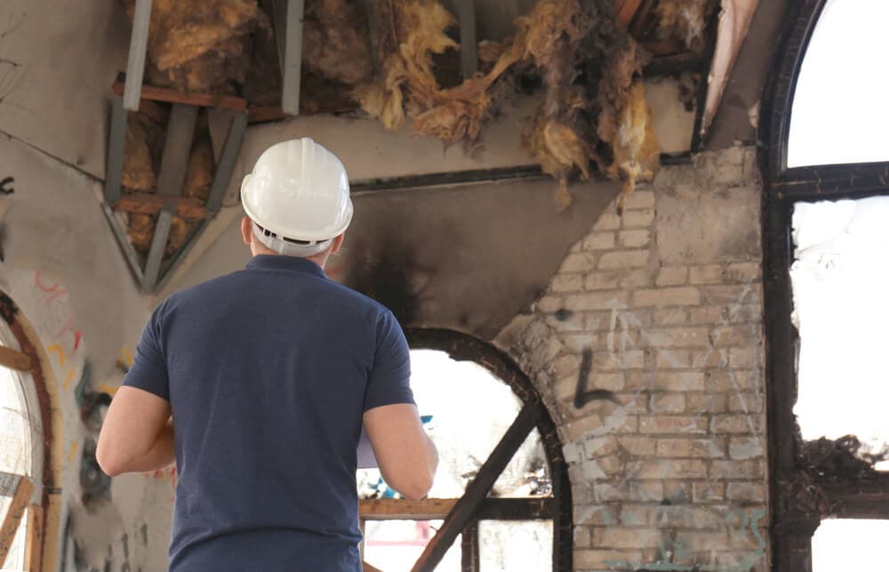 Insurance adjuster examines damage after a home fire - cheap home insurance in CA.