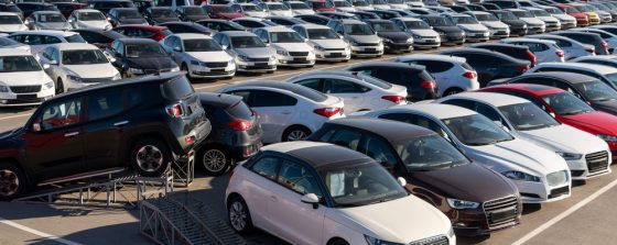 Large parking lot filled with rows of new cars in various makes, models, and colors, illustrating a broad selection of vehicles available for purchase.