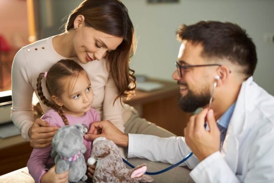 Small girl having a medical appointment with her mother at pediatricians' office, free or low-cost health insurance in California.