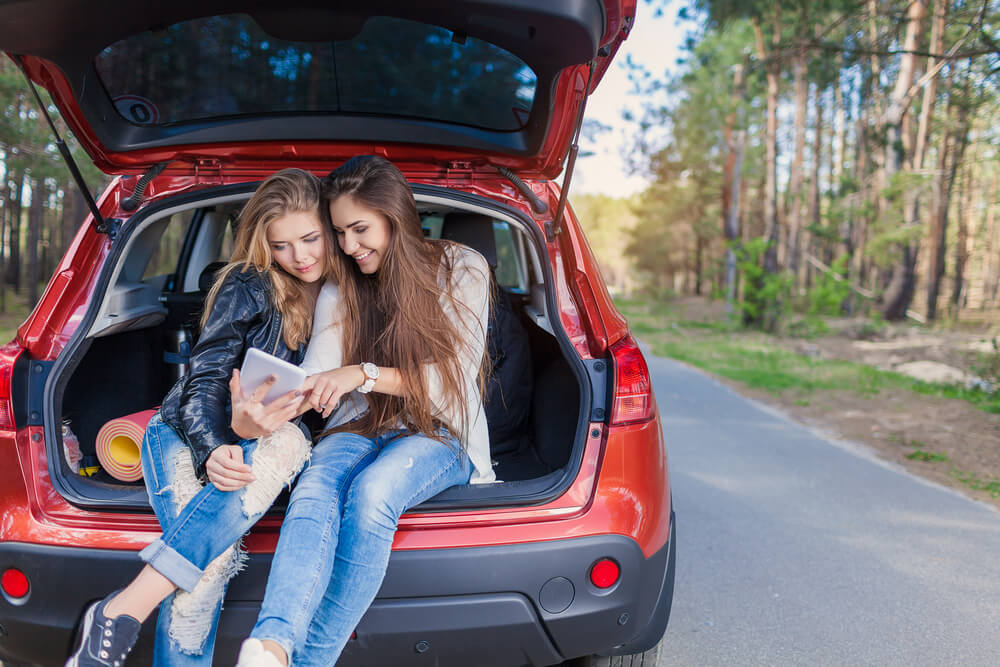 Two female college friends take a little road trip, car insurance for college students.