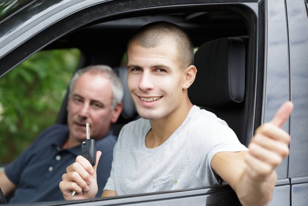 Young man driving his car for the first time, looks for cheap car insurance in California.