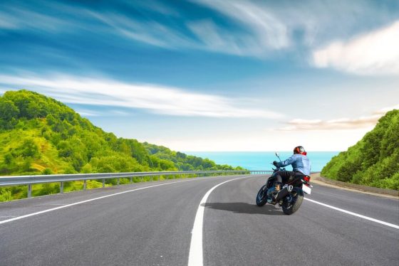 Motorcycle drive on a coastal road landscape in summer in California with the Pacific Ocean in view.