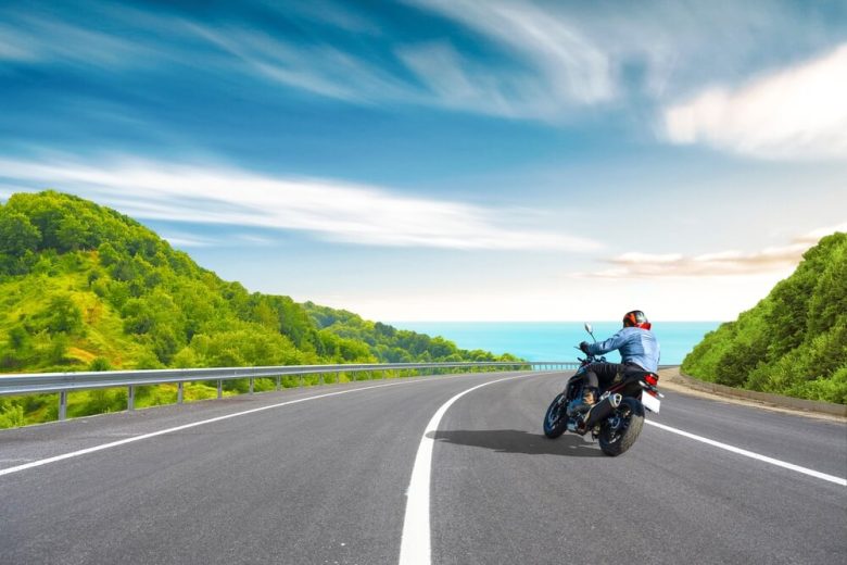 Motorcycle drive on a coastal road landscape in summer in California with the Pacific Ocean in view.