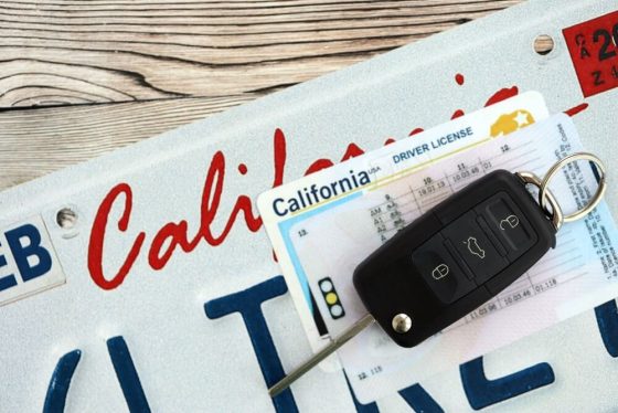 California driver license and car keys resting on a license plate, symbolizing the steps needed to reinstate car insurance in California before legally driving again.