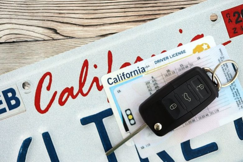 California driver license and car keys resting on a license plate, symbolizing the steps needed to reinstate car insurance in California before legally driving again.