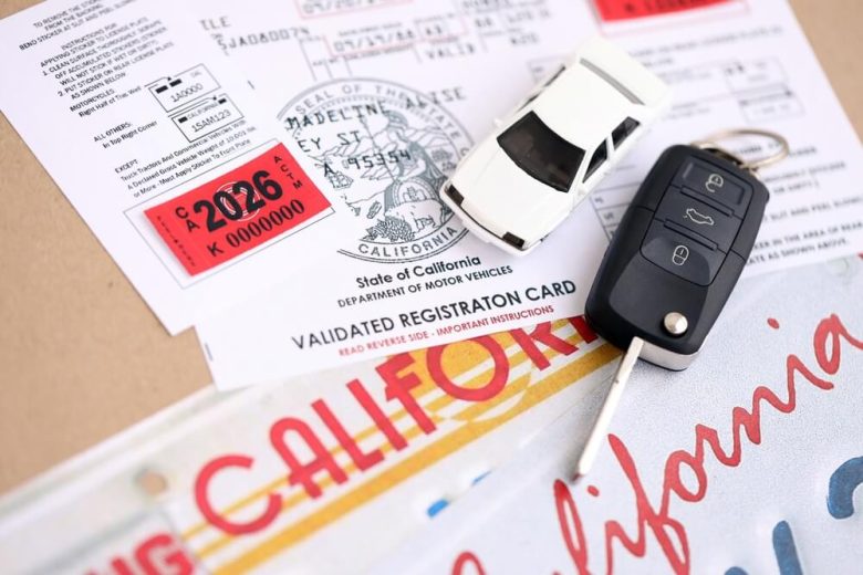 California vehicle registration card, license plate, and car key displayed together, representing requirements for car insurance out of state plates California.