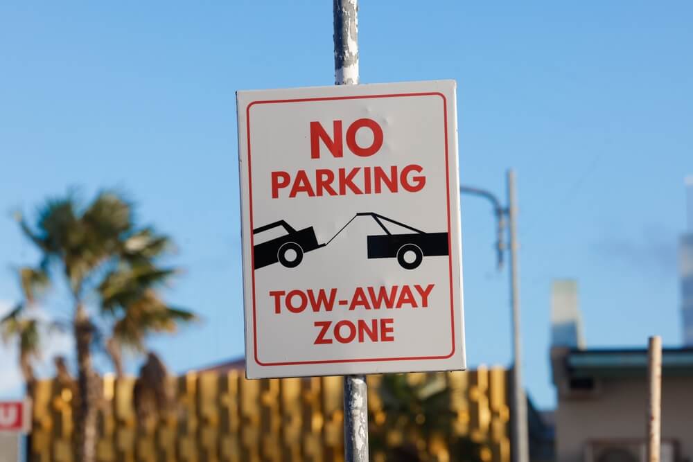 No parking tow-away zone sign on a street, representing car towing in California rules and the importance of having car insurance.
