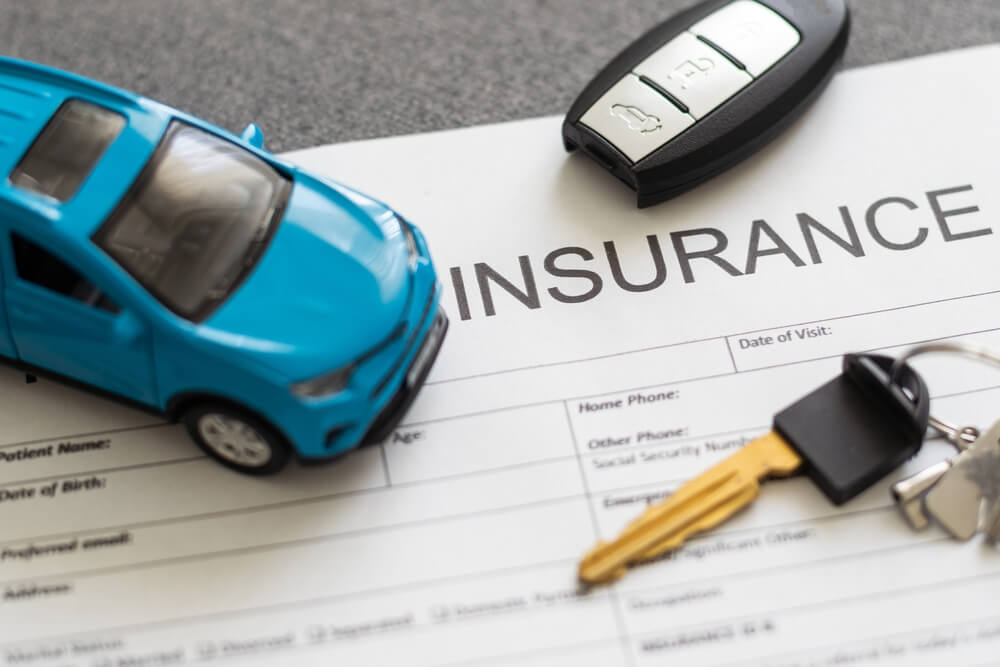 Car insurance policy with a vehicle, car keys, and key fob, representing coverage for mechanical failures and car insurance.