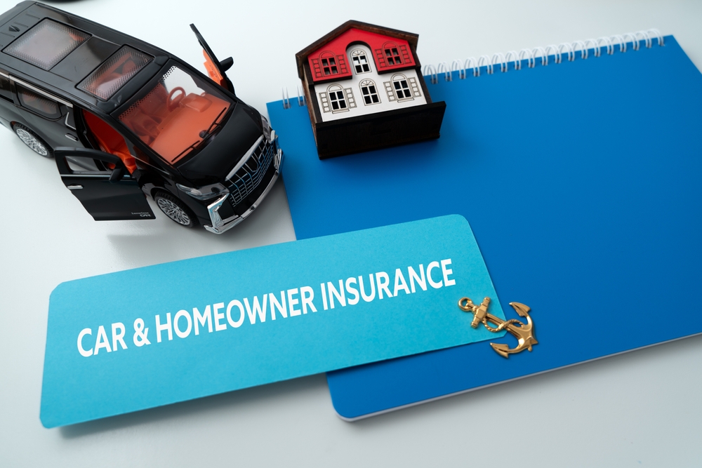 Car and model home representing bundled home and auto insurance coverage.