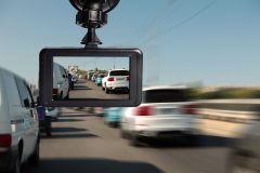 Dash cam mounted inside a car records vehicles traveling in heavy traffic, illustrating dash cam use for car insurance claims.
