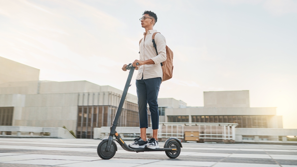 Man riding an electric scooter for electric scooter insurance.