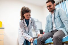 Médico examinando a un paciente, relacionado con un seguro de vida con beneficios en vida en USA.