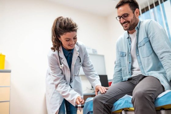 Médico examinando a un paciente, relacionado con un seguro de vida con beneficios en vida en USA.