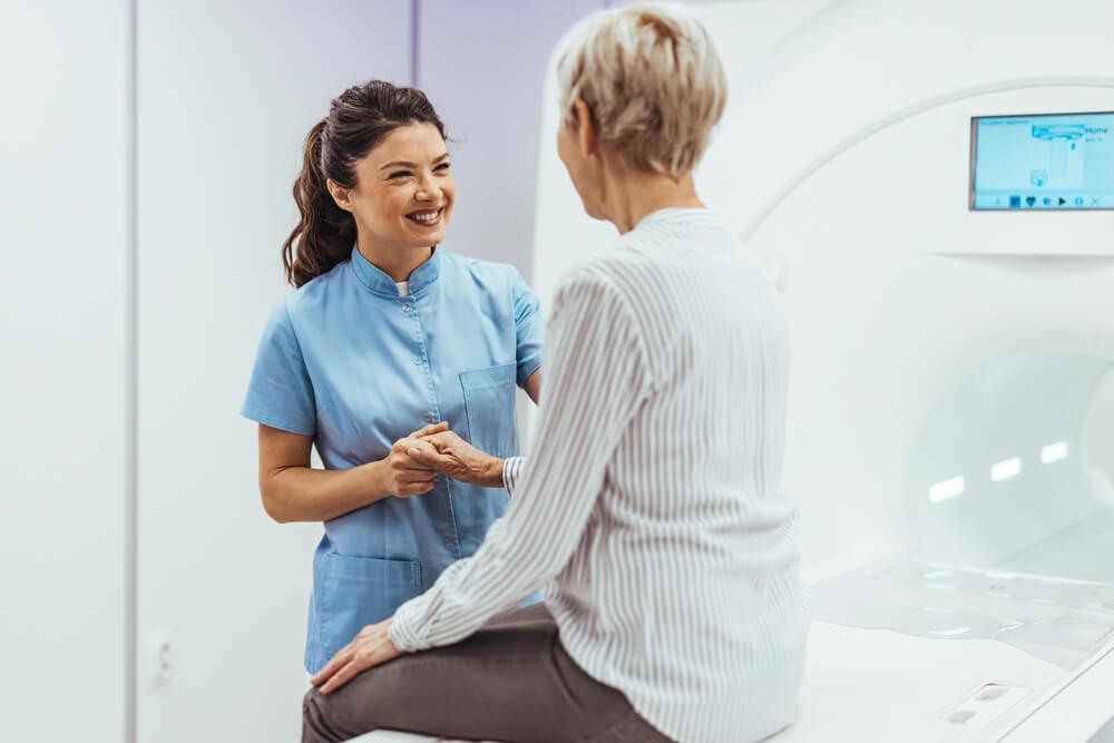 Profesional de la salud atendiendo a una paciente antes de un estudio médico, relacionado con beneficios en vida.