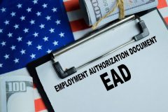 Documento de autorización de empleo (EAD) sobre una bandera de Estados Unidos junto a dinero en efectivo, representando el permiso de trabajo en EE. UU.