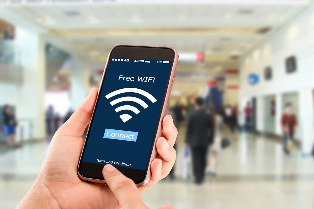 Mano agarrando un celular en una plaza conectandose a una red pública después de descubrir cómo encontrar wifi gratis en USA