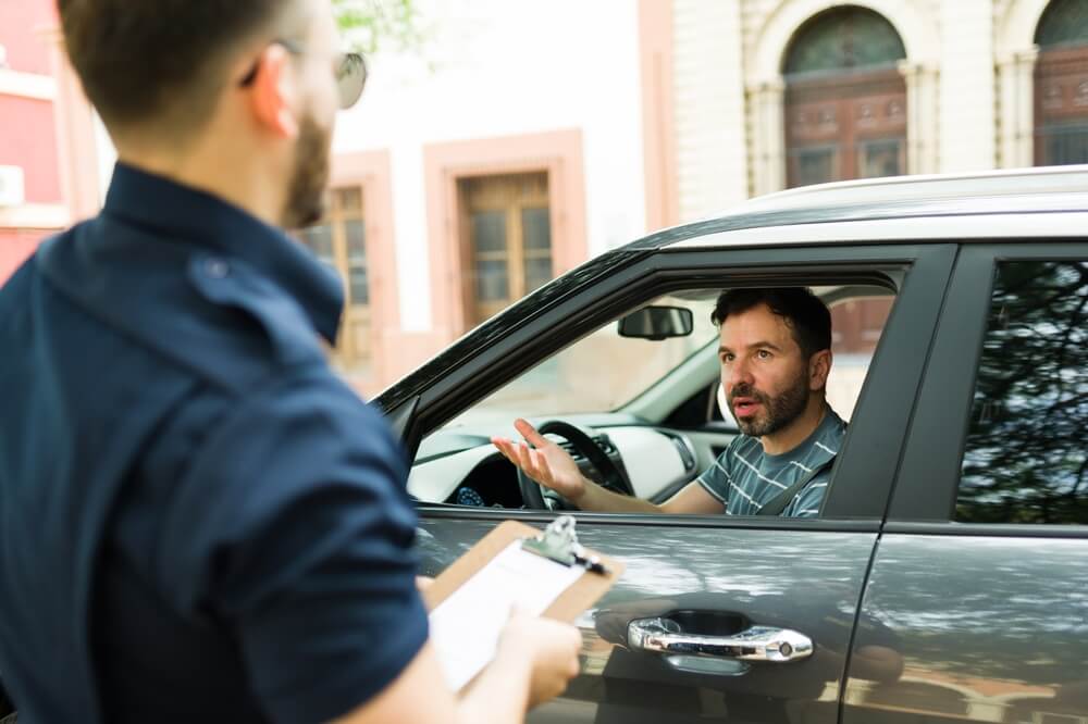 Conductor mostrando su licencia de conducir a un oficial de policia