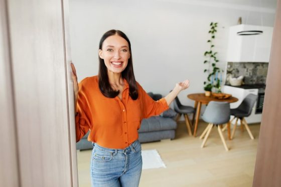 Propietaria mostrando el interior de su vivienda, representando la protección que ofrece un seguro de casa con responsabilidad civil en California para propietarios y sus bienes.