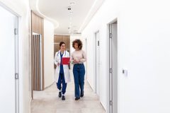 Mujer consultando con una doctora sobre opciones de seguro de salud después de los 26 años.
