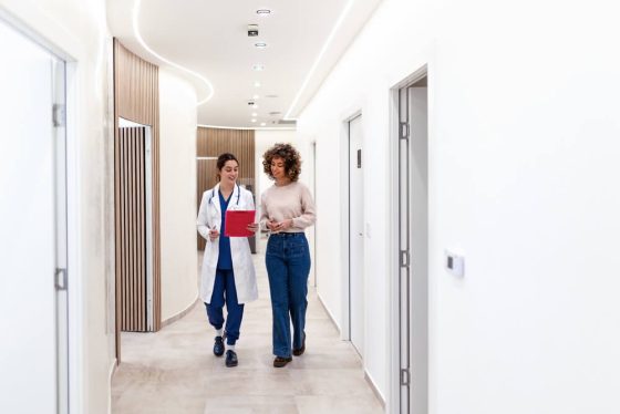Mujer consultando con una doctora sobre opciones de seguro de salud después de los 26 años.