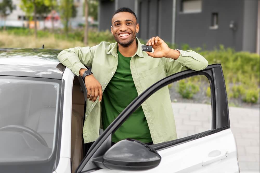 Conductor sonriente muestra las llaves de su auto ya pagado, una buena ocasión para revisar tu **seguro después de pagar por completo tu auto**.