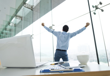 Stressed business man stretching in his office.