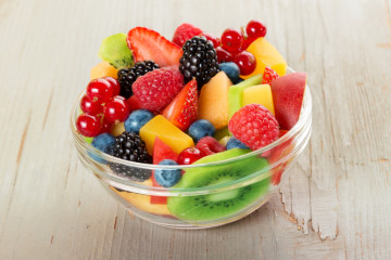 bowl of fruit salad isolated on wood table