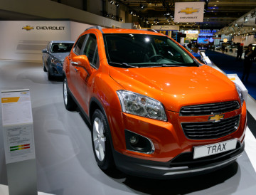 Chevrolet Trax compact SUV on display at the 2014 Brussels motor show. People in the background are looking at the cars.