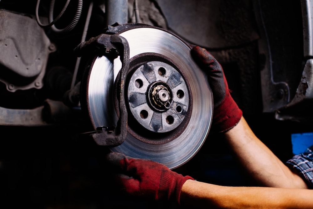 mechanic installing anti lock brakes on a car with hands