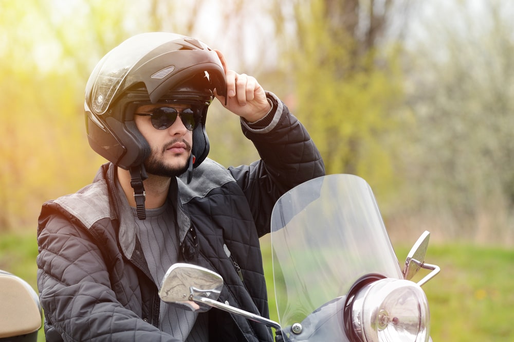 man in motorcycle putting his helmet visor up