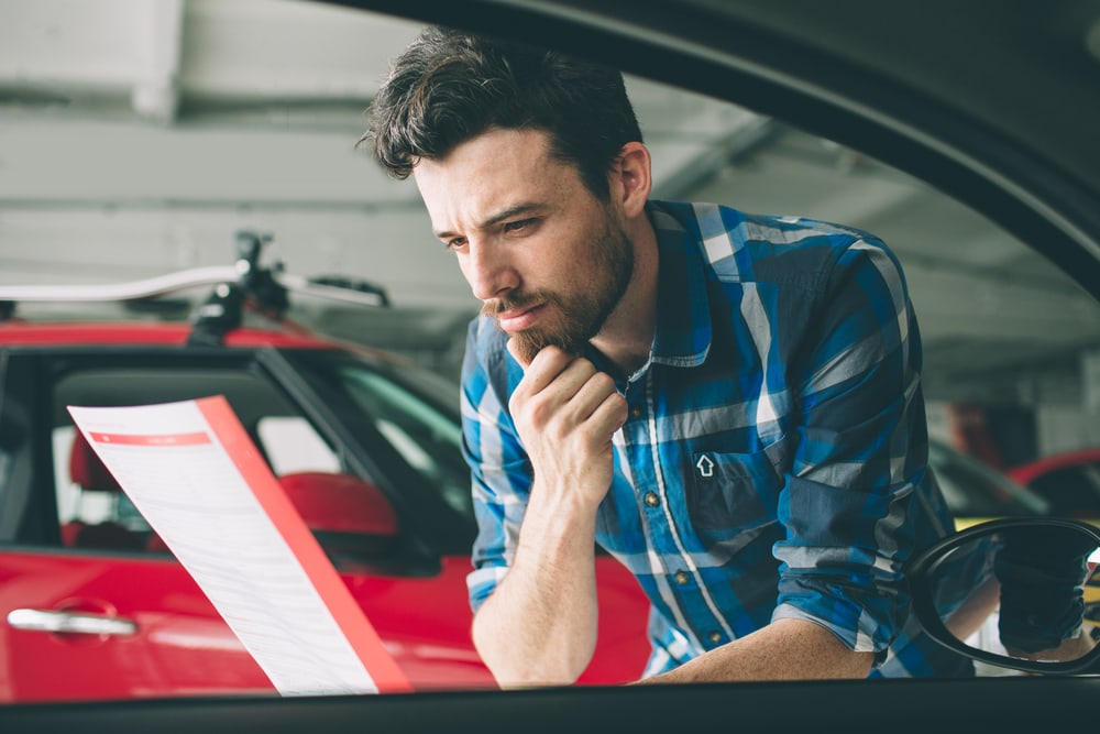 young man looking at buying a used car