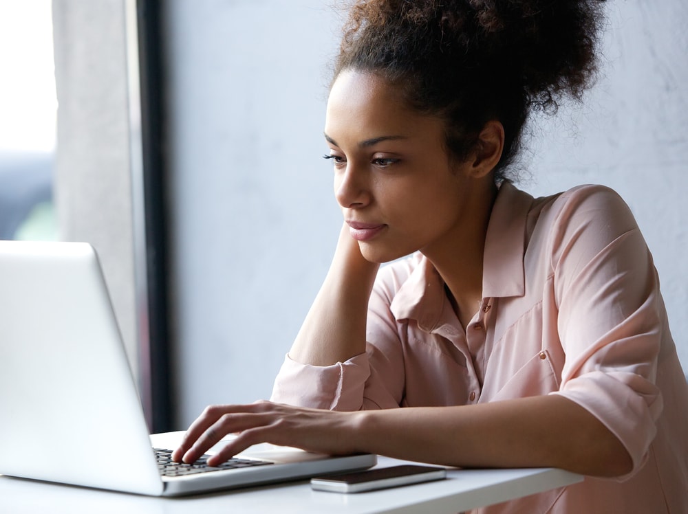 young woman looking at laptop for car insurance