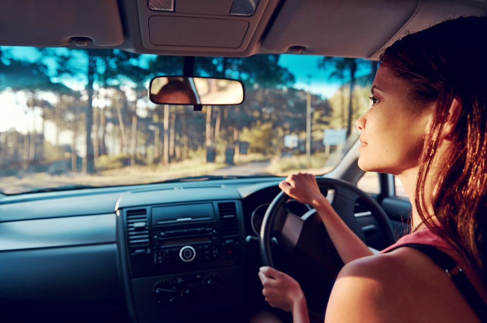 inside view of woman driving car with insurance in california